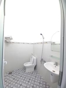 a white bathroom with a toilet and a sink at Nhà nghỉ Mỹ Nhật - Đảo Phú Quý -Bình Thuận in Cu Lao Thu +14 photos