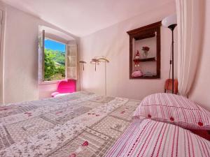 a white bedroom with a bed and a window at La casa con giardino, vicino al ruscello segreto in Borzonasca