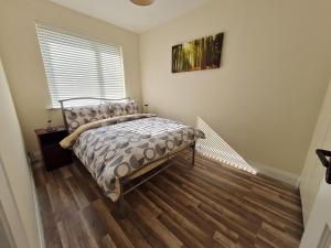 a bedroom with a bed and a wooden floor at Farnaught Farmhouse Apartment, Lough Rynn, Mohill in Farnaght