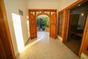 un corridoio aperto con porte in legno in una casa di Skardu Orchard Guest House a Skardu