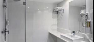 a white bathroom with a shower and a sink at B&B HOTEL Madrid Pinar de las Rozas in Las Rozas de Madrid