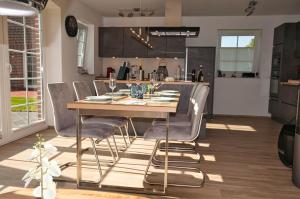 cocina y comedor con mesa de madera y sillas en Haifisch en Greetsiel