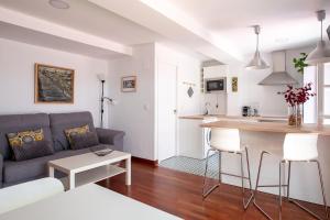 sala de estar y cocina con sofá y mesa en Calle San Jacinto, 57 Apartamento, en Sevilla