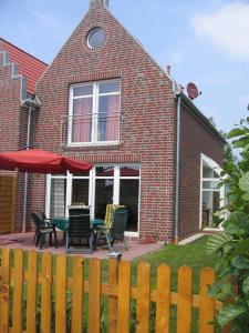 a brick house with a patio with a table and chairs at Anika in Norddeich