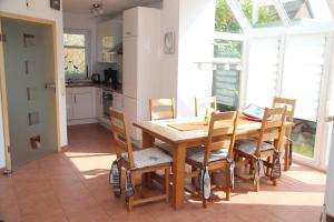 a kitchen with a wooden table and chairs at Anika in Norddeich