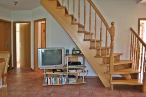 a living room with a television and a staircase at Friesenstern in Norden