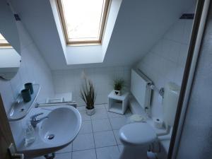 a bathroom with a sink and a toilet and a window at Friesenstern in Norden +14 photos