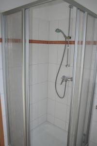 a shower with a glass door in a bathroom at Möwennest in Norddeich +14 photos