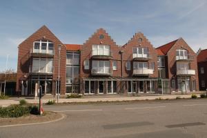 a large brick building on the side of a street at Möwennest in Norddeich