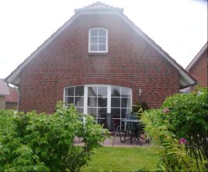 a brick house with a table and chairs in a yard at See in Sicht in Sternberg