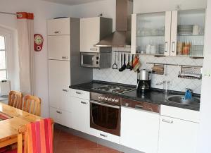 a kitchen with white cabinets and a stove top oven at See in Sicht in Sternberg