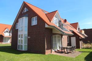 a house with a table and chairs in the yard at Ebbe in Norden
