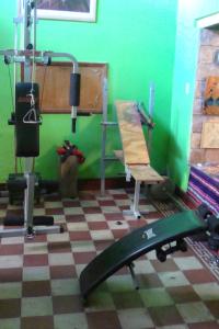 a room with a gym with a surfboard and a chair at Intiaconcagua Habitaciones Familiares in Ciudad Lujan de Cuyo