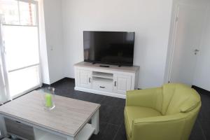 a living room with a yellow chair and a television at Matjes in Greetsiel