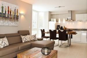 a living room and kitchen with a couch and a table at Kiek up de Gracht in Greetsiel