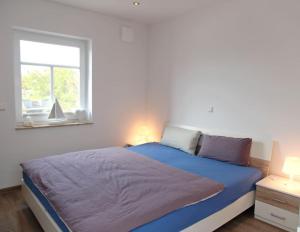 1 dormitorio con 1 cama grande y ventana en Sonnengruß, en Greetsiel