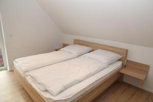 1 cama con 2 almohadas en una habitación en Grachtenhüsje, en Greetsiel