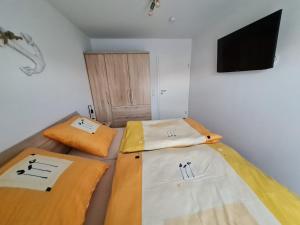 Duas camas num quarto com uma televisão na parede em Grachtendrööm em Greetsiel