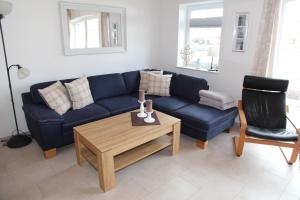a living room with a blue couch and a table at Bei Ruhe in Loppersum