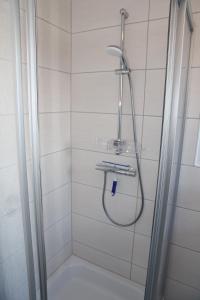 a shower with a hose in a bathroom at Bei Ruhe in Loppersum