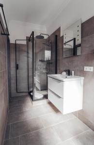 a bathroom with a white sink and a shower at Hotel Boutique am Schloss in Schleswig