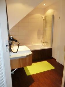 uma casa de banho com uma banheira, um lavatório e um chuveiro em Huus an't Gracht em Greetsiel