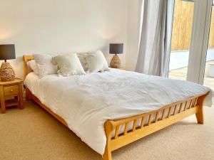 ein großes Bett mit weißer Bettwäsche und Kissen im Schlafzimmer in der Unterkunft Rye Court Cottage and Annex Central Hemsley in Helmsley