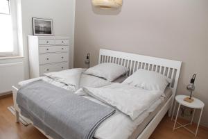 ein Bett mit weißen Laken und Kissen in einem Schlafzimmer in der Unterkunft Biene in Greetsiel