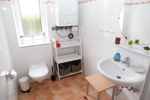 ein weißes Badezimmer mit Waschbecken und Toilette in der Unterkunft Biene in Greetsiel