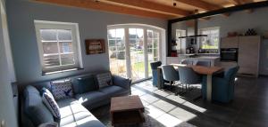 a living room with a blue couch and a table at Dat Hygge Huus in Greetsiel