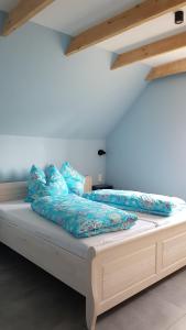 a bed with blue sheets and blue pillows on it at Dat Hygge Huus in Greetsiel