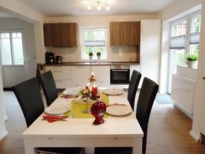 a kitchen with a white table with chairs and a dining room at Gesine's Huuske in Eilsum