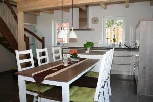 a kitchen with a wooden table and white chairs at Stella Maris in Norden
