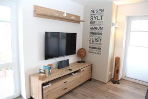 a living room with a flat screen tv on a wall at Zinnenhuus 1 in Greetsiel
