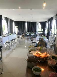 a dining room with tables and chairs and food on display at Thanh Thu 1 Hotel in Kon Tum