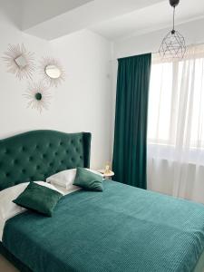 1 dormitorio con cama verde y cabecero verde en Royal Reed Apartments, en Mamaia Nord – Năvodari