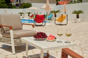 - une table avec deux verres de vin et un bol de fruits dans l'établissement Georgiy Lux Apartments, à Lastva