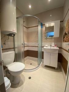 a bathroom with a shower and a toilet and a sink at Апартамент SUMI in Varna City