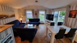 ein Wohnzimmer mit einem blauen Sofa und einem Tisch in der Unterkunft Seacottage Brugge - Blankenberge - De Haan in De Haan