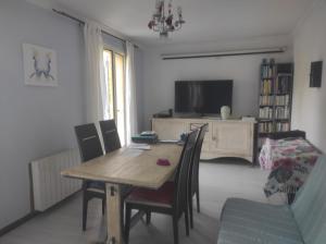 a dining room with a wooden table and chairs at Chambre spatieuse avec grand lit. in Aspet