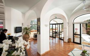 una sala de estar con paredes blancas y ventanas arqueadas. en Hotel Royal Positano, en Positano