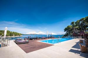 a swimming pool with a view of the ocean at Hotel Maxim in Božava
