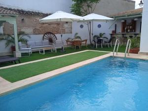 uma piscina com mesa e cadeiras e um guarda-sol em LA CASA DE JULIA em Almagro