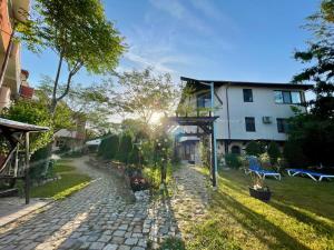 a cobblestone path in a yard next to a house at H by Hambar in Vama Veche