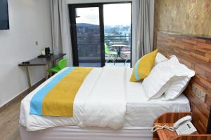 a bedroom with a large bed and a balcony at Centric Hotel in Kigali