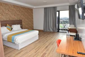 a hotel room with a bed and a table at Centric Hotel in Kigali
