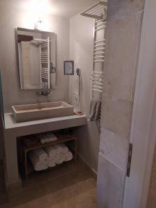 uma casa de banho com lavatório, espelho e toalhas em Wild Violet Villa: an old vision of luxury em Melidhónion