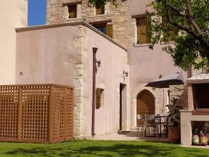 uma entrada para uma casa com uma cerca de madeira em Wild Violet Villa: an old vision of luxury em Melidhónion