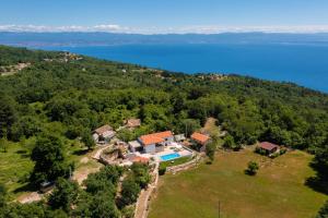 z góry widok na dom na wzgórzu nad wodą w obiekcie Villa Simici quiet peaceful place with pool perfect to enjoy the nature w mieście Mošćenička Draga