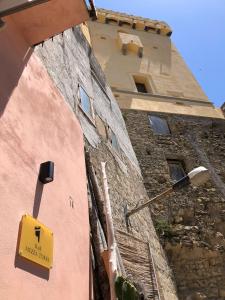 a building with a yellow sign on the side of it at Mezza Torre B&B in Procida